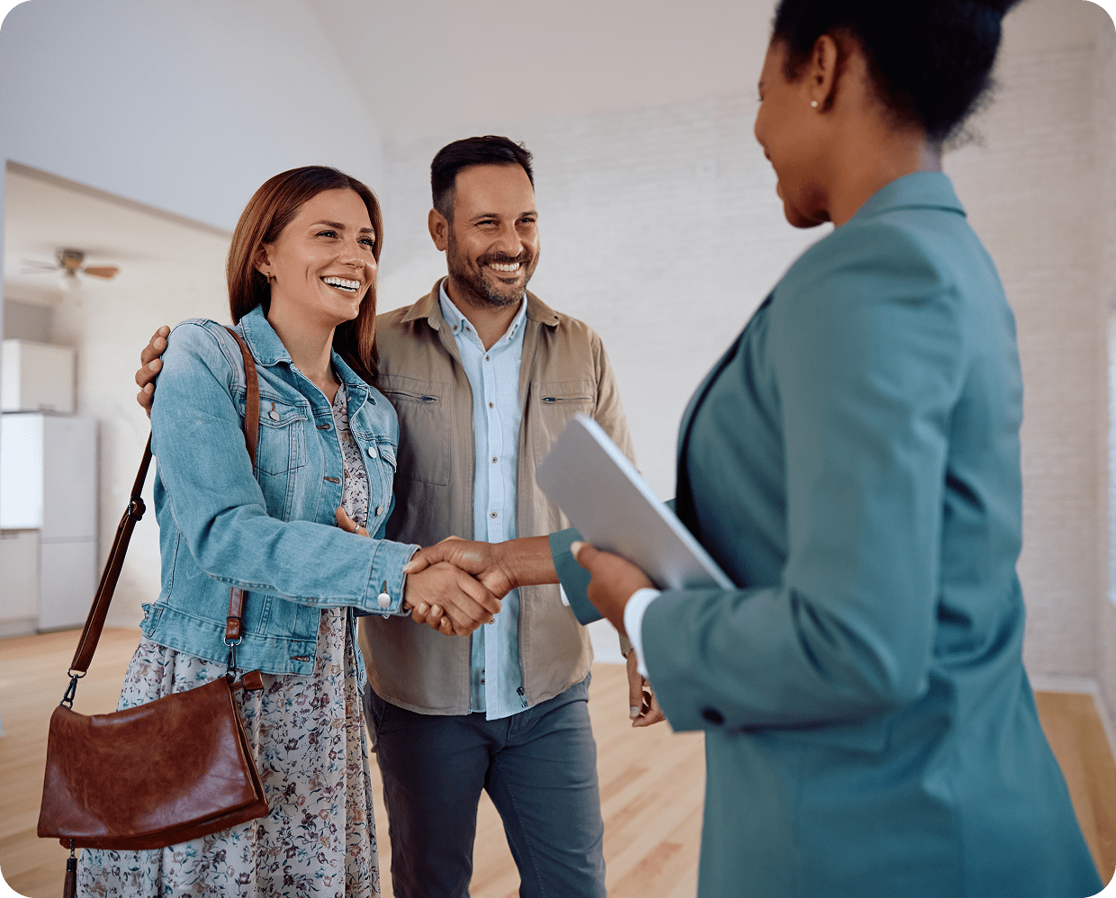 Couple shaking hands with real estate agent.
